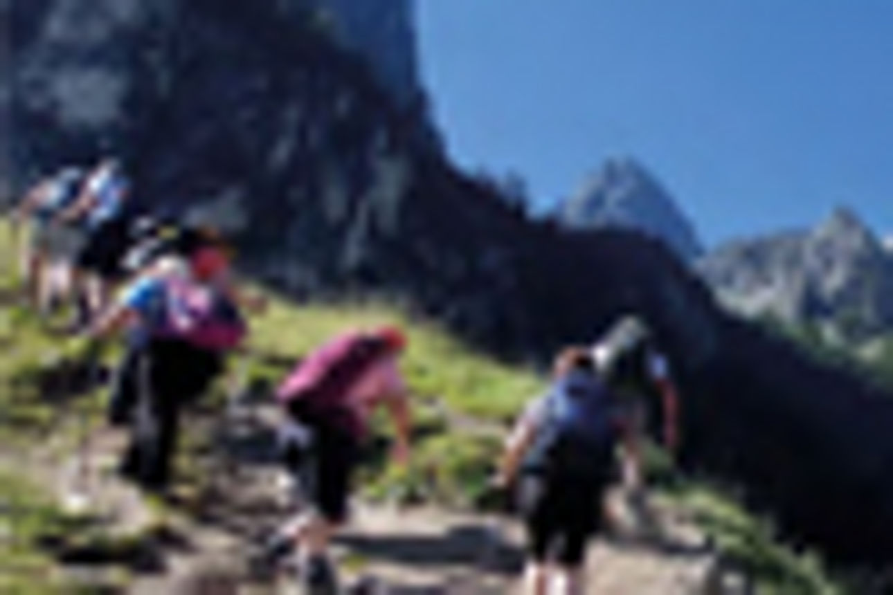 Eine Gruppe von Wanderern beim Aufstieg auf einen Bergpfad