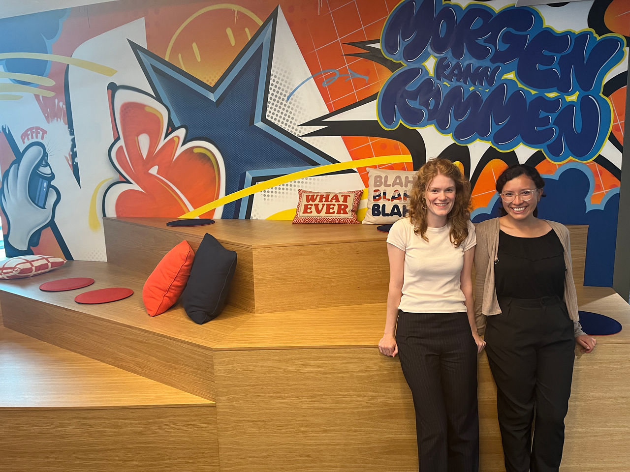 Andrea Lozada Andramuno aus Ecuador mit Sophie Hargreaves vor einer Graffiti Wand im Gebäude der VR-Bank Ludwigsburg.