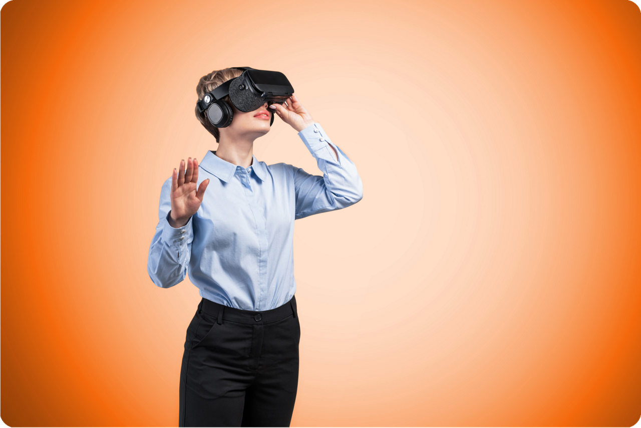Ein Frau mit aufgesetzter VR Brille steht vor einem orangenem Hintergrund