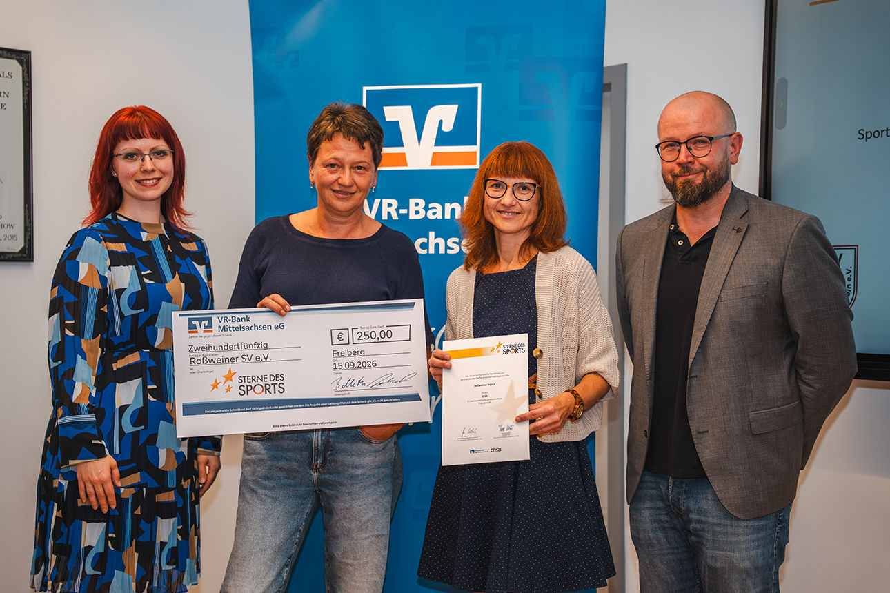 Ein Mann und drei Frauen bei der Vergabe des Förderpreises mit Urkunde und Scheck