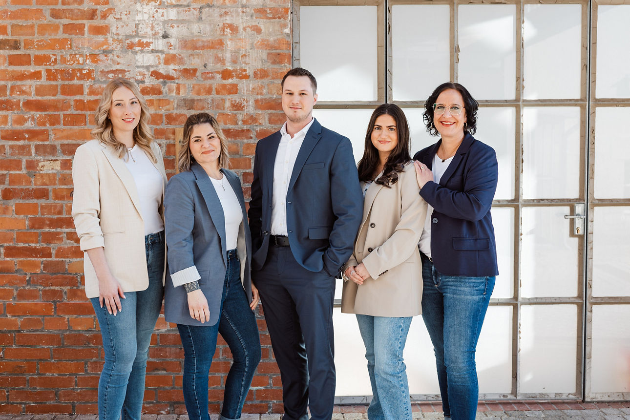 Eine vielfältige Gruppe von Menschen steht vor einer Wand