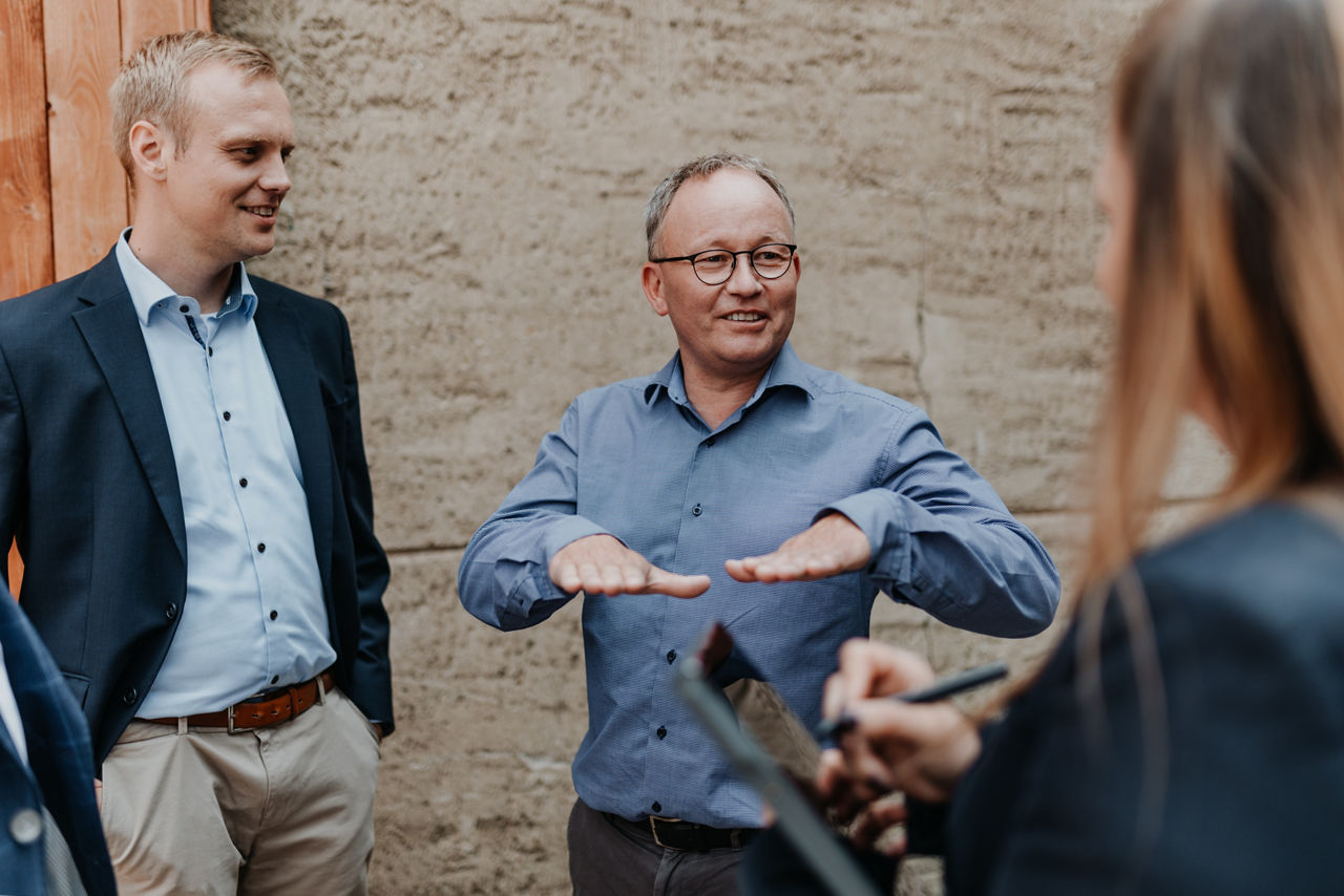 Zwei Personen in Business Kleidung lächeln und sprechen
