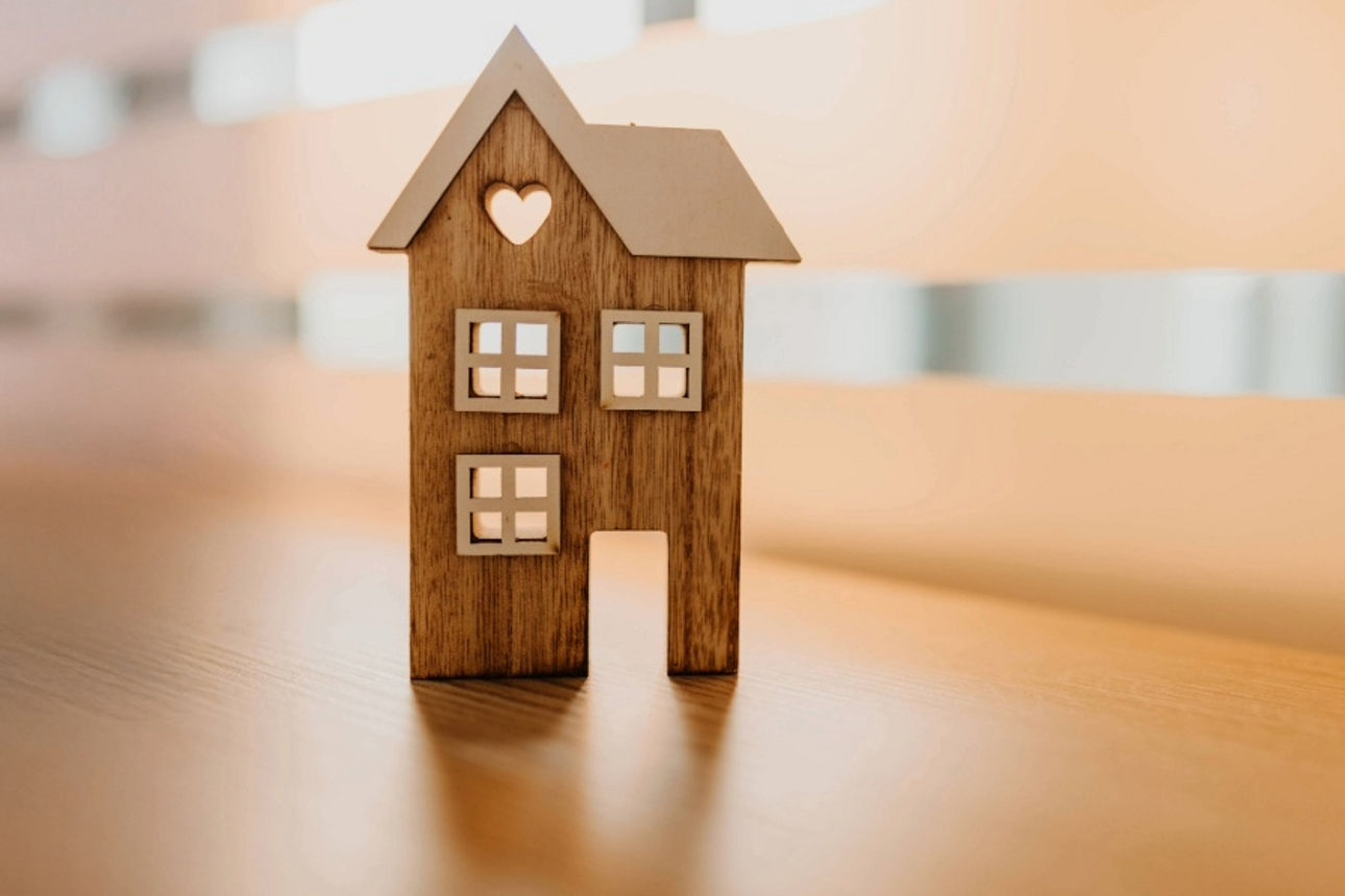 Ein kleines Holzhausmodell, das auf einem Tisch ausgestellt ist