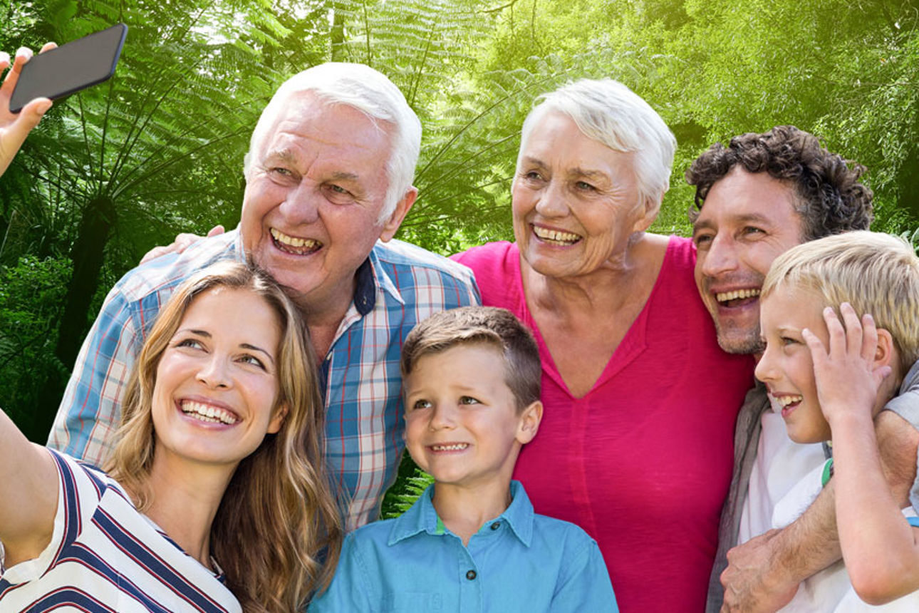 Eine Familie macht ein Selfie im Grünen