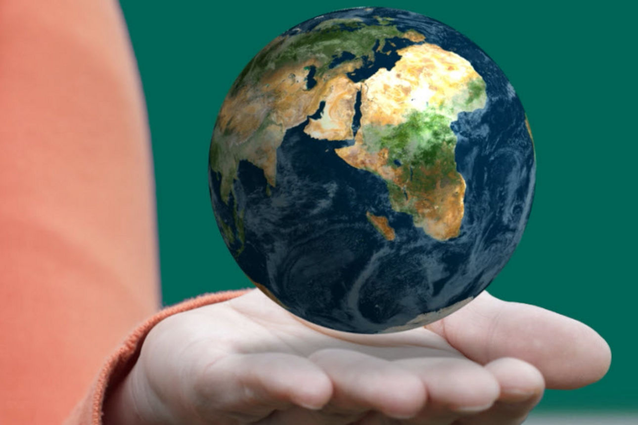Eine geöffnete Hand über der eine Weltkugel schwebt