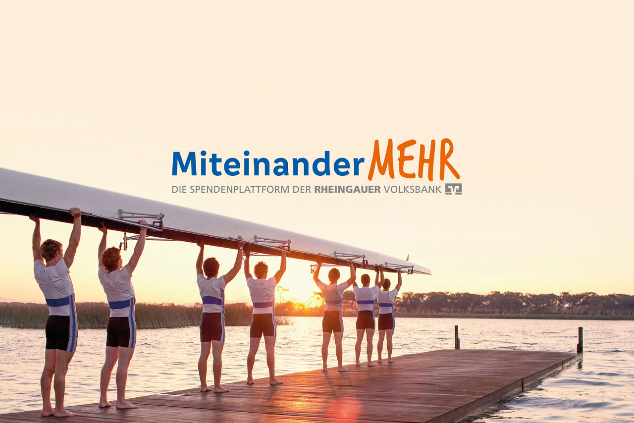 Sieben Ruderer tragen ein Boot über einen Steg bei Sonnenuntergang am Wasser, darüber der Schriftzug 'Miteinander MEHR' und Hinweis auf die Spendenplattform der Rheingauer Volksbank
