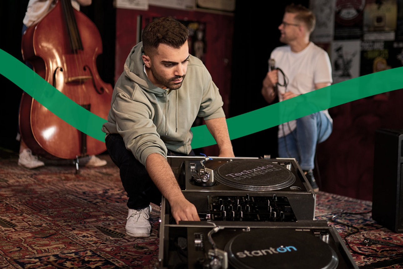 Ein Mann baut ein DJ Pult auf. 