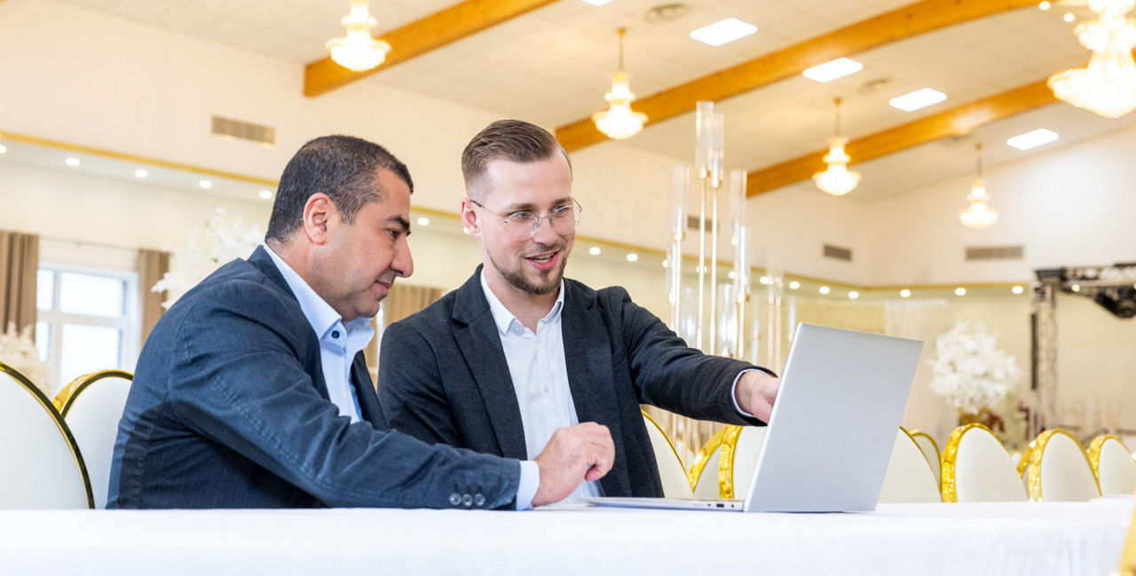 Zwei Männer sitzemn vor einem Laptop
