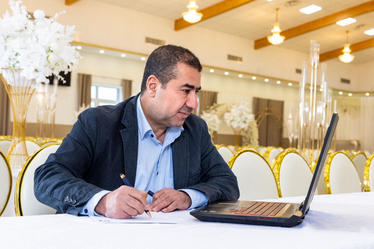 Geschäftsführer schreibt und schaut in einen Laptop