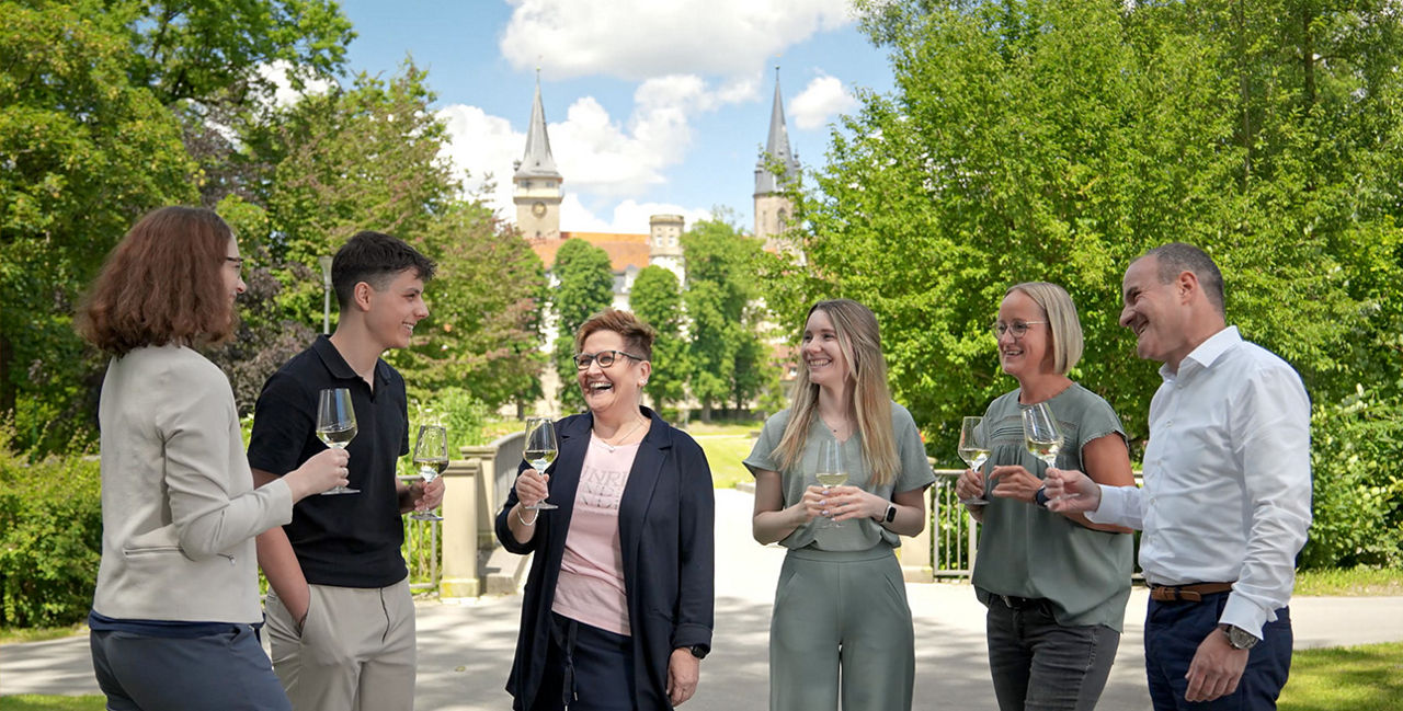 Mitarbeiter von der Volksbank Hohenlohe eG stoßen zusammen an und lachen