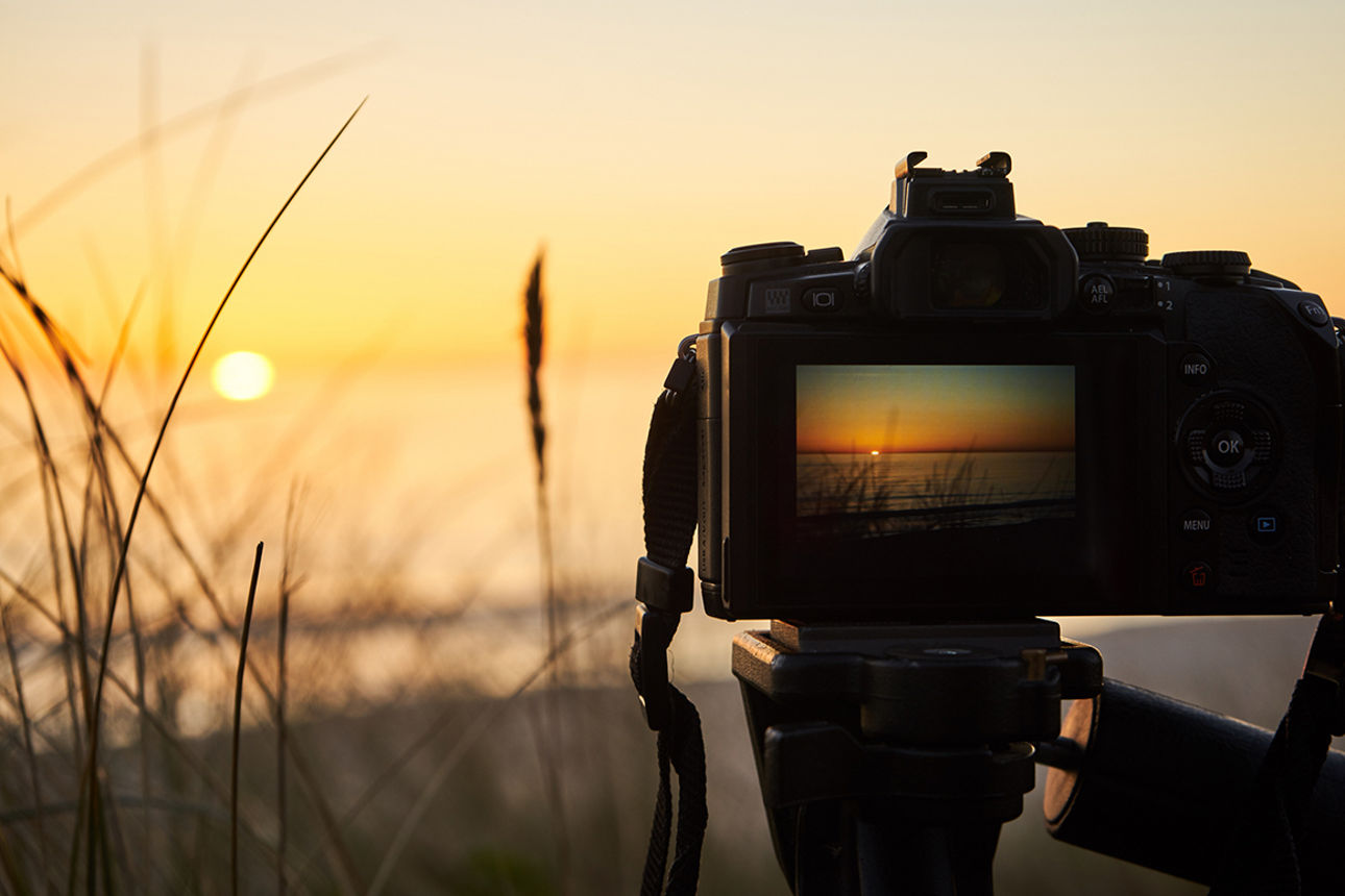 Kamera, die einen Sonnenuntergang fotografiert.