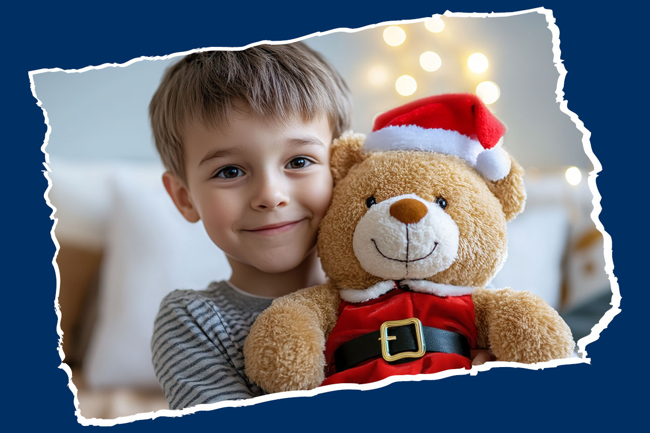 Kind lächelnd mit Weihnachtsmann Teddybär