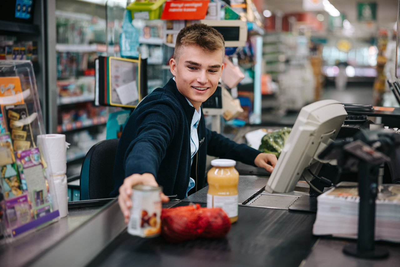 Junge Person an Supermarktkasse