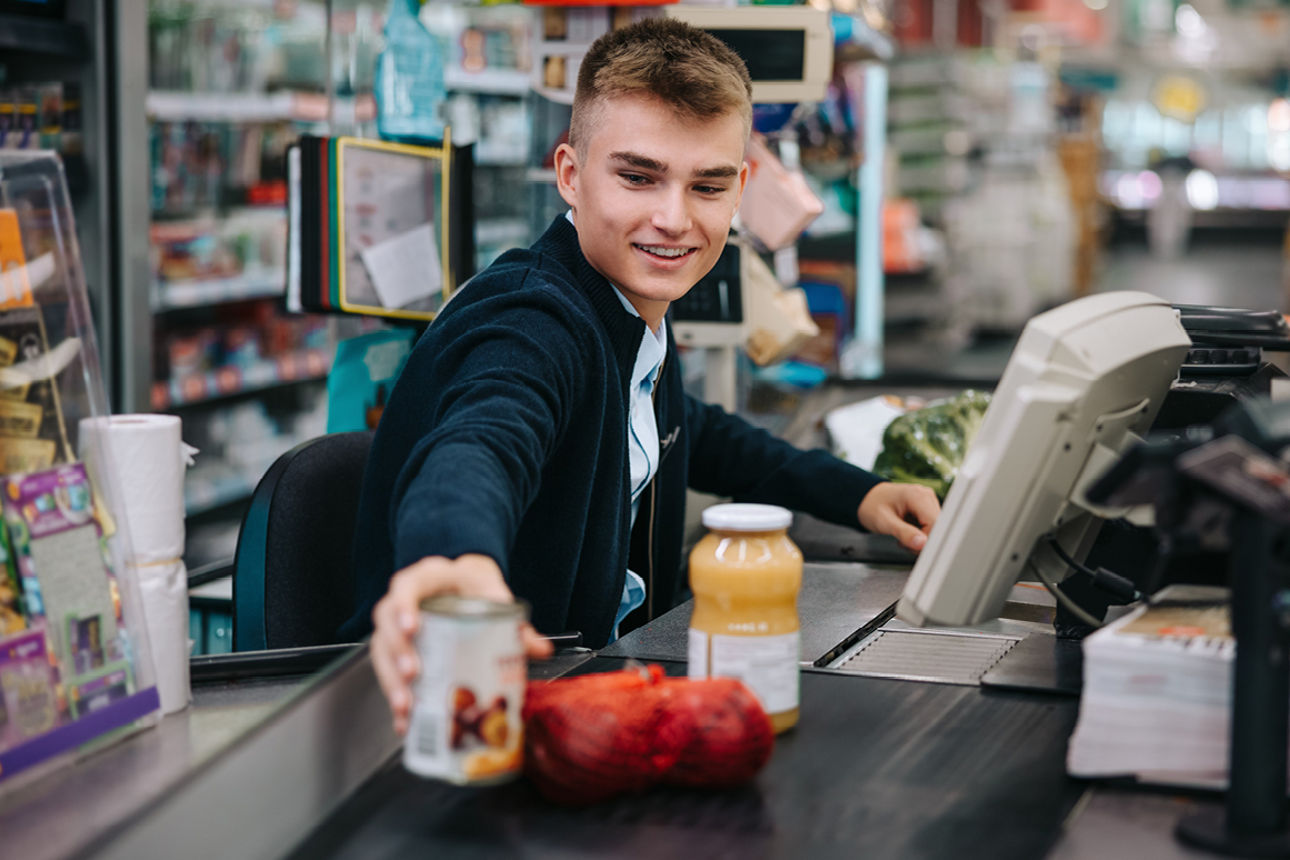 Junge Person an Supermarktkasse