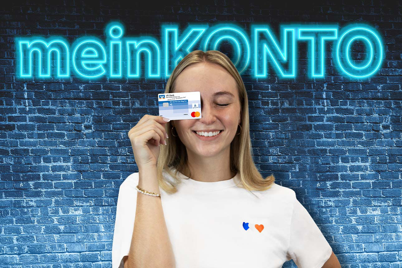 Junge Frau hält Bankkarte vor das Gesicht, im Hintergrund leuchtender Schriftzug ‚meinKONTO‘ auf blauer Ziegelwand.