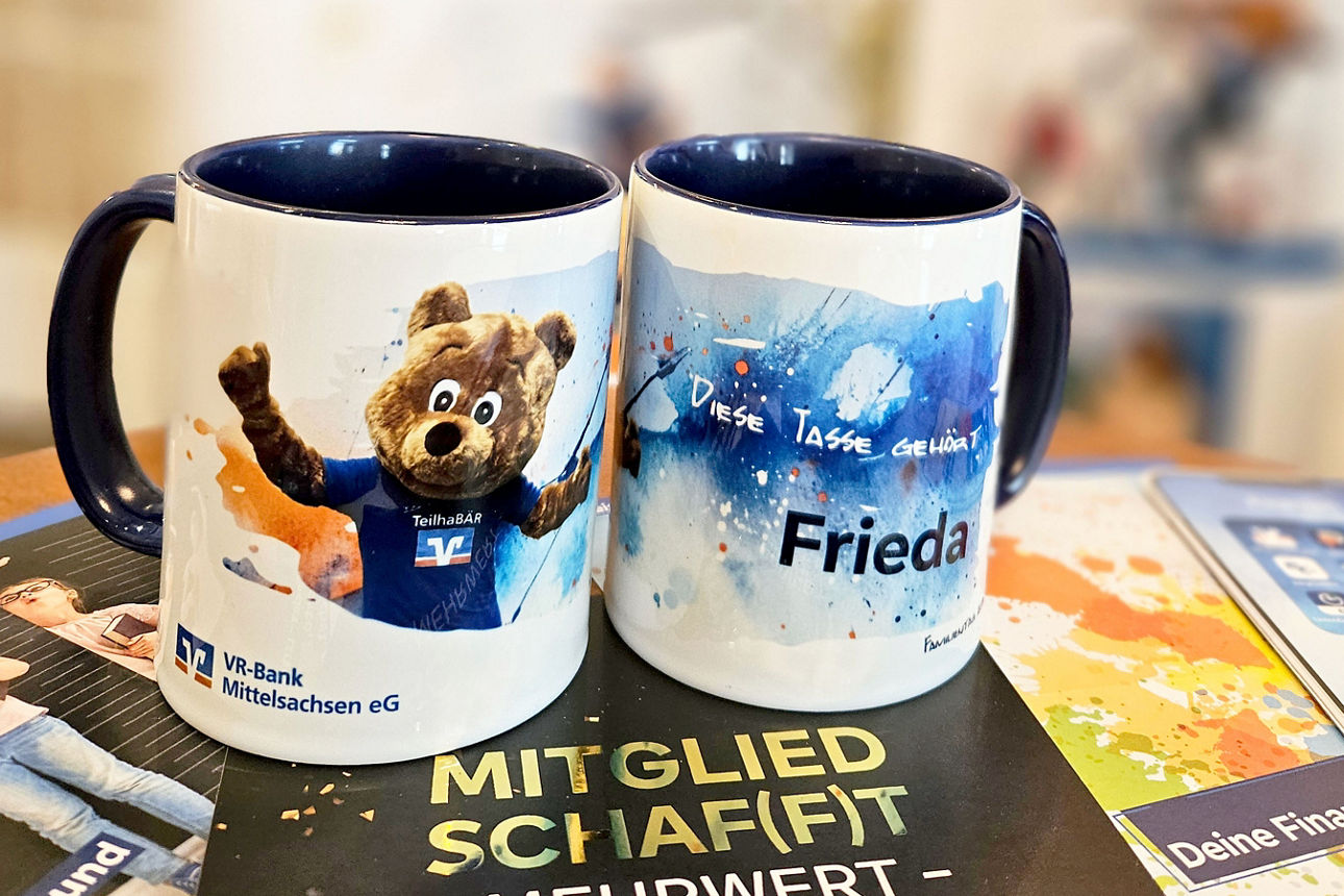 Zwei Tassen mit einem Motiv vom Maskottchen der VR-Bank Mittelsachsen
