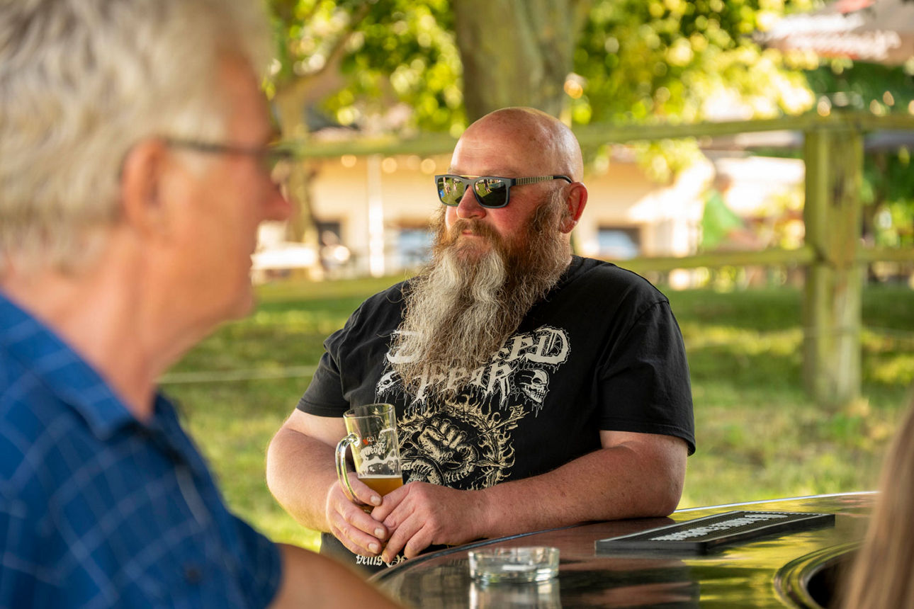 Ein bärtiger Gast mit Sonnenbrille am Bierstand