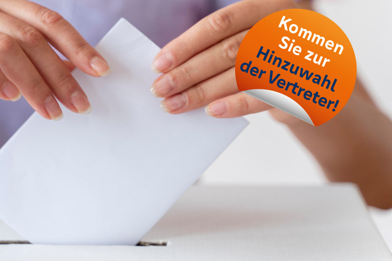 Nahaufnahme einer Person, die einen weißen Stimmzettel in einen schmalen Schlitz wirft