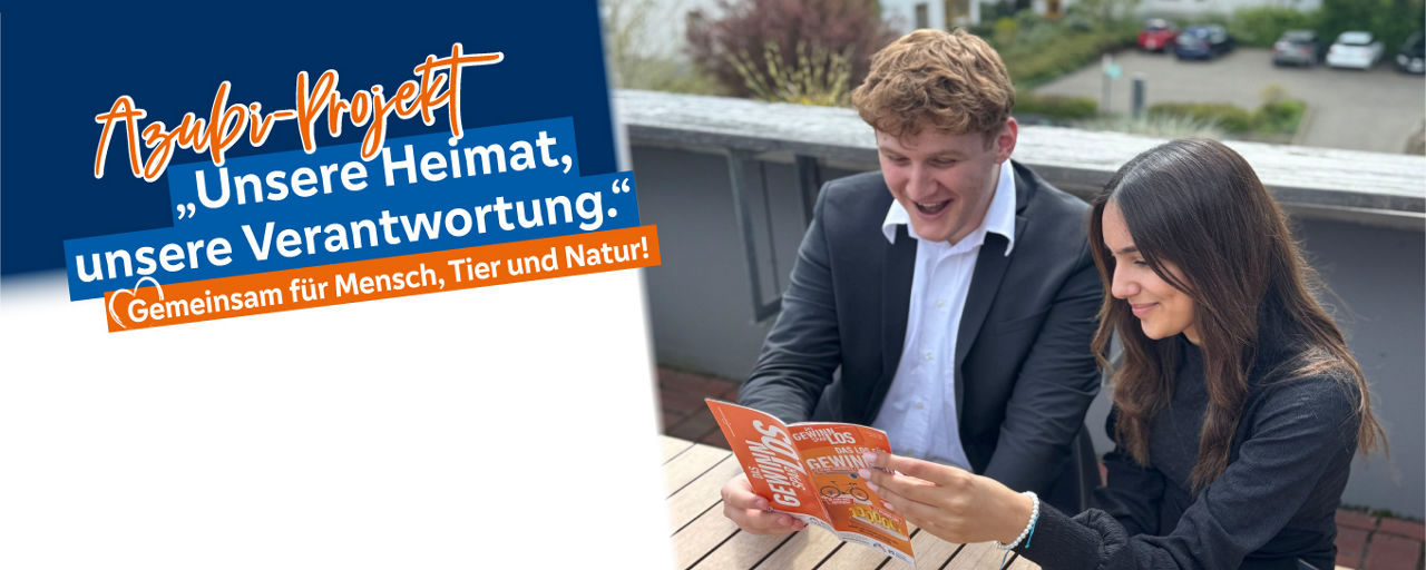 2 Azubis sitzen an einem Tisch und lesen den Gewinnsaprflyer