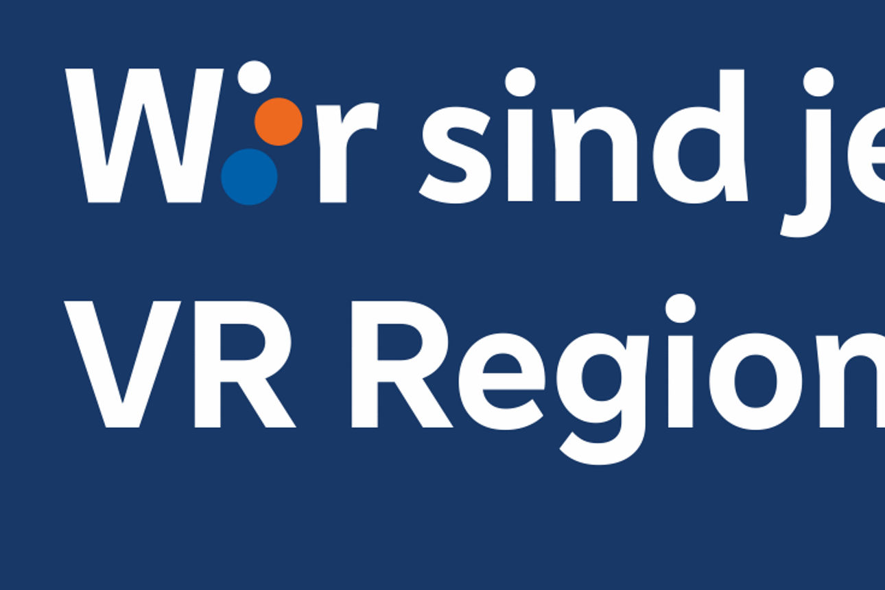 Dunkelblaue Grafik mit weißem Text: „Wir sind jetzt VR RegionalBank.“ Das „i“ in „Wir“ ist orange-blau gestaltet.