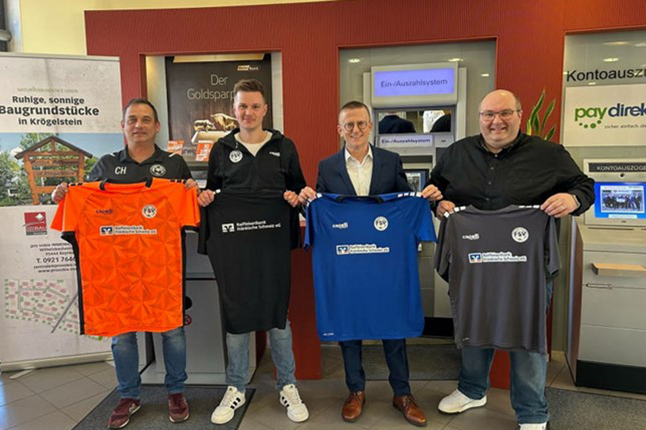 Vier Mäner halten das Trikot in den Händen