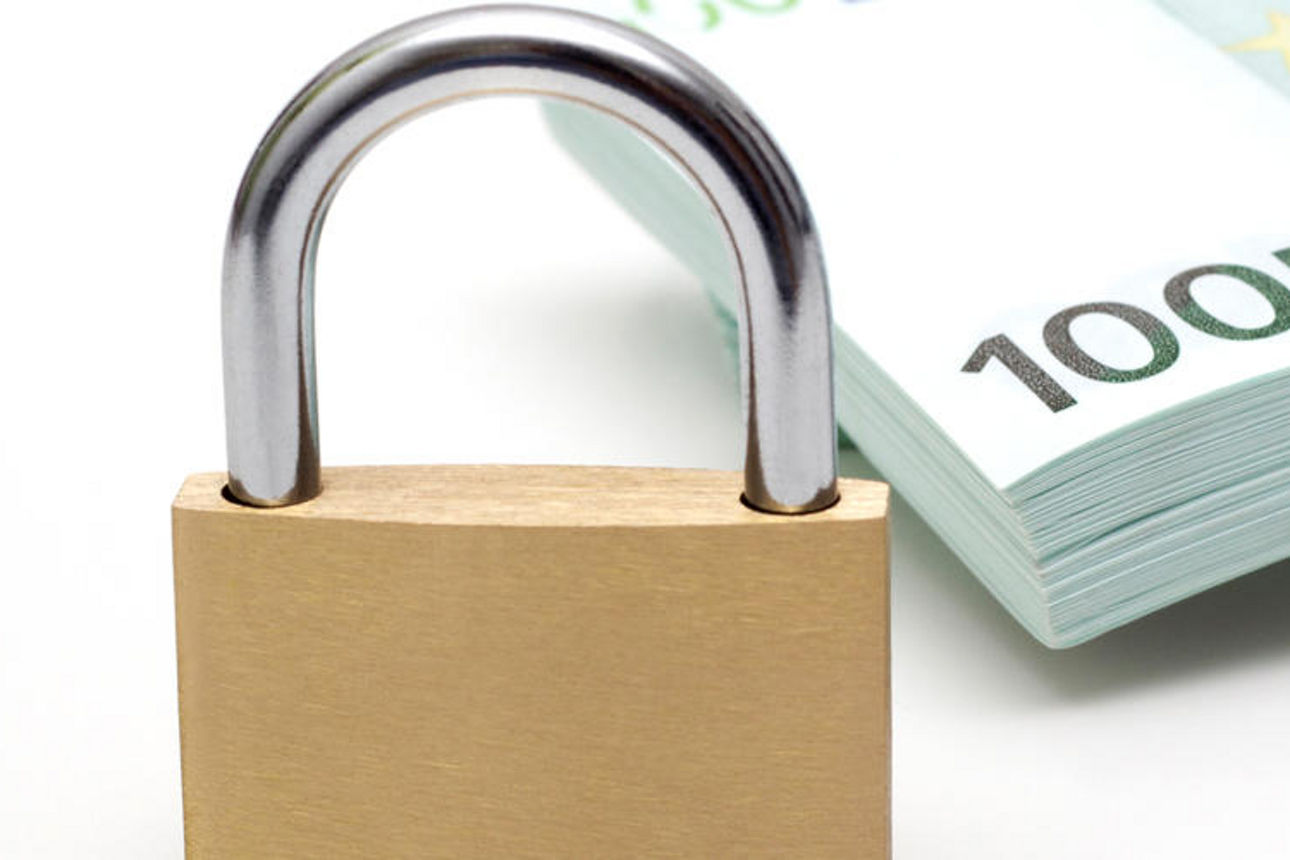 Ein Vorhängeschloss, das auf einem Stapel von Euro-Banknoten ruht