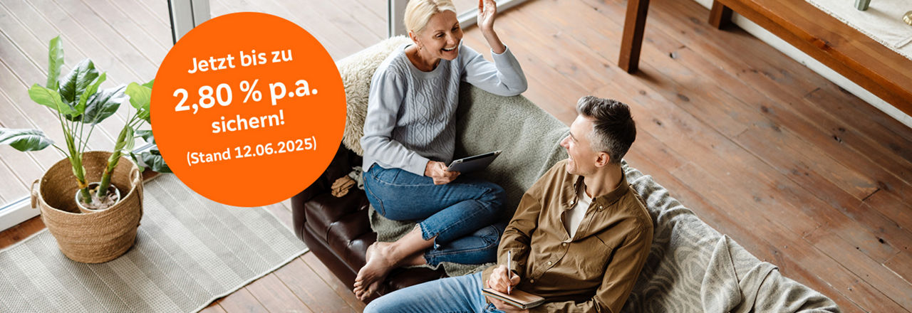 Ehepaar sitzt auf dem Sofa und spricht miteinander