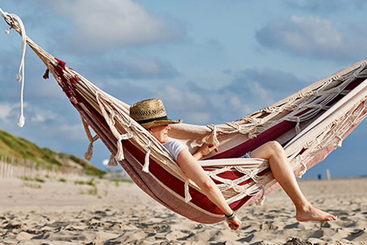 Ein Mann in einer Hängematte am Strand