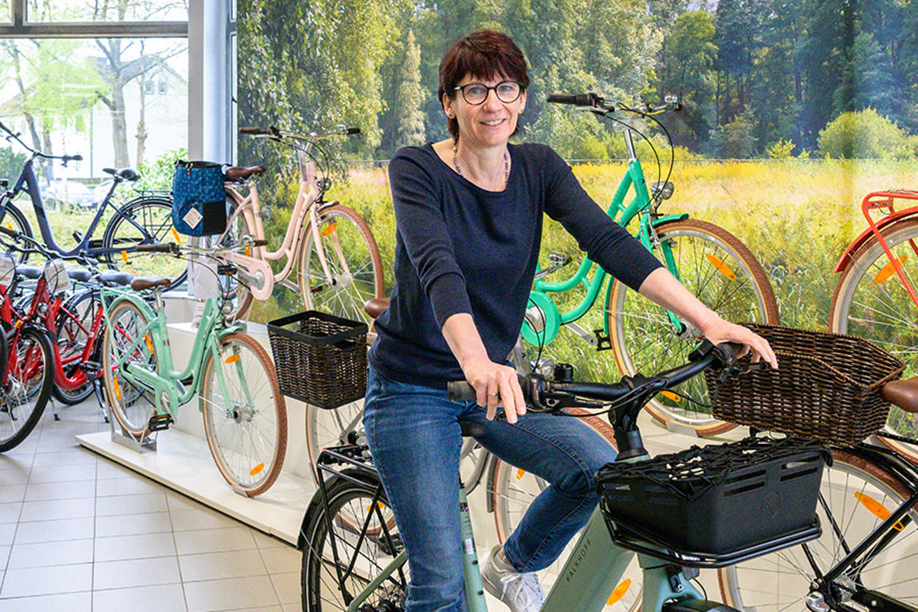 Karina Sandau auf einem Fahrrad in ihrem Geschäft