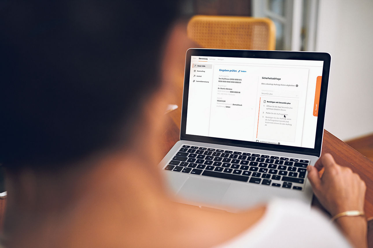 Person nutzt Laptop mit Online-Banking-Ansicht, Arbeiten am Computer im Innenraum