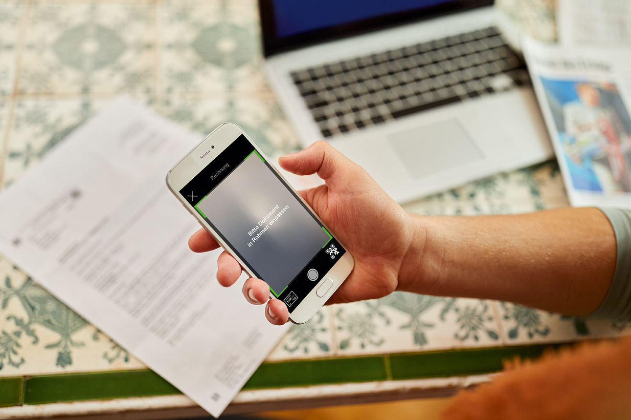 Person scannt eine REchnung mit dem Smartphone