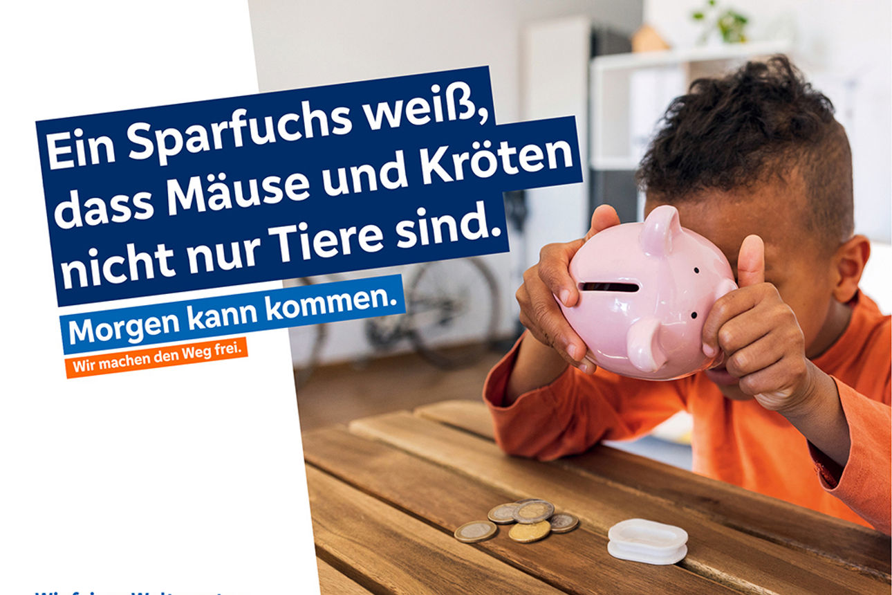 Ein kleines Kind hält vorsichtig ein rosa Sparschwein aus Keramik in der Hand.