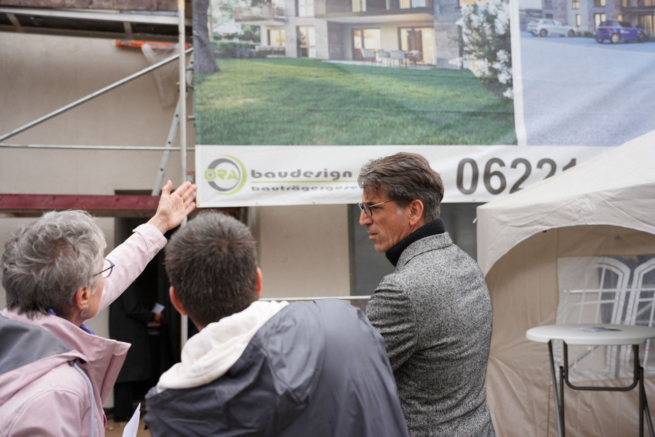 Bankmitarbeiter mit Kunden vor dem Bauprojekt
