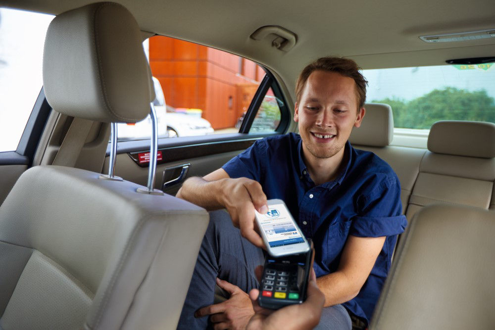 Ein junger Mann bezahlt mit seinem Handy