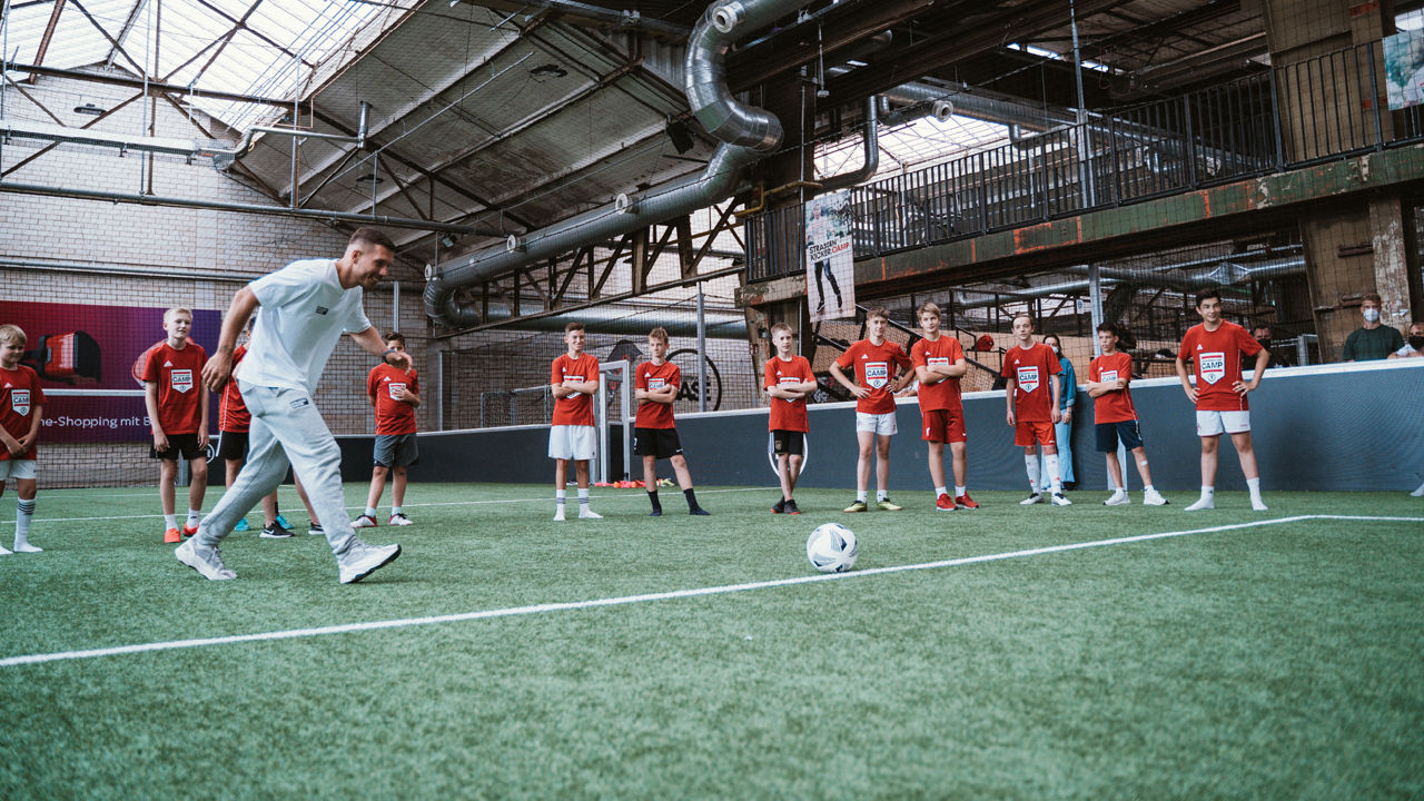 Lukas Podolski ist beim Ferien-Fußballcamp für Kinder in der Strassenkicker.Base zu Gast