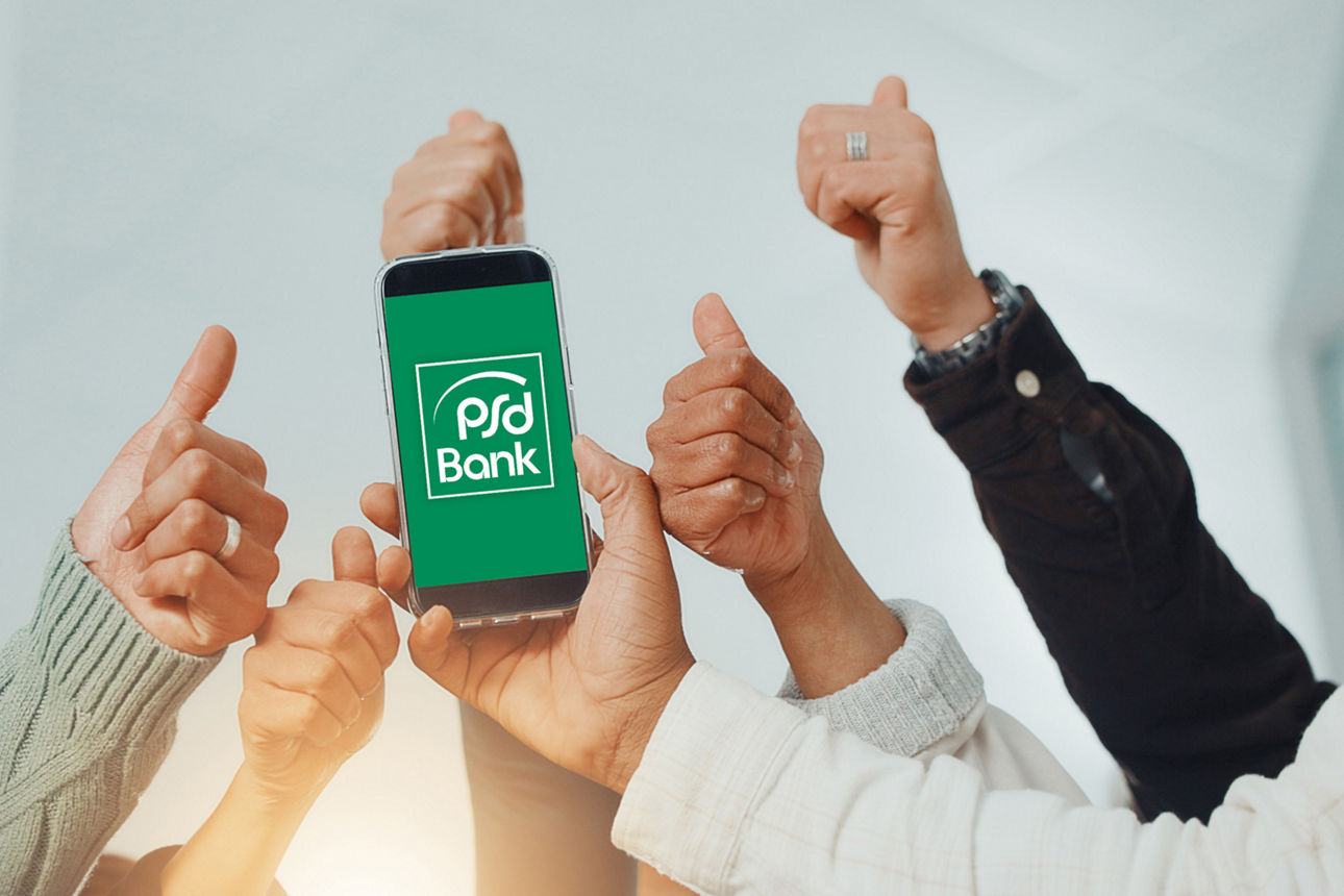 Sechs Hände mit einem Handy und mit einem Logo auf dem Display "PSD Bank"