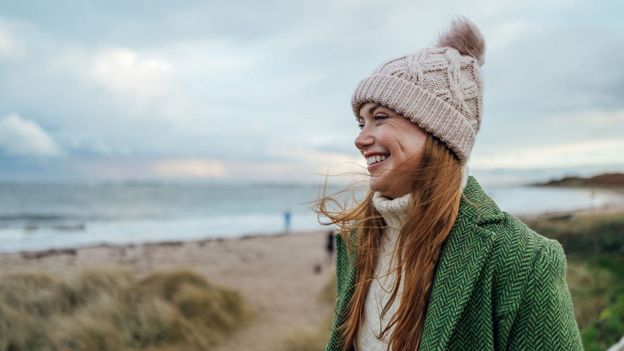 Frau mit Mütze am Strand