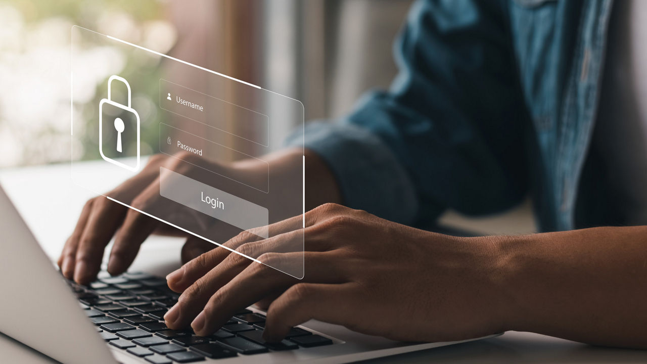 Eine Person tippt auf die Tastatur eines Laptops. Virtuell wird der Inhalt des Bildschirms über den Händen dargestellt. 