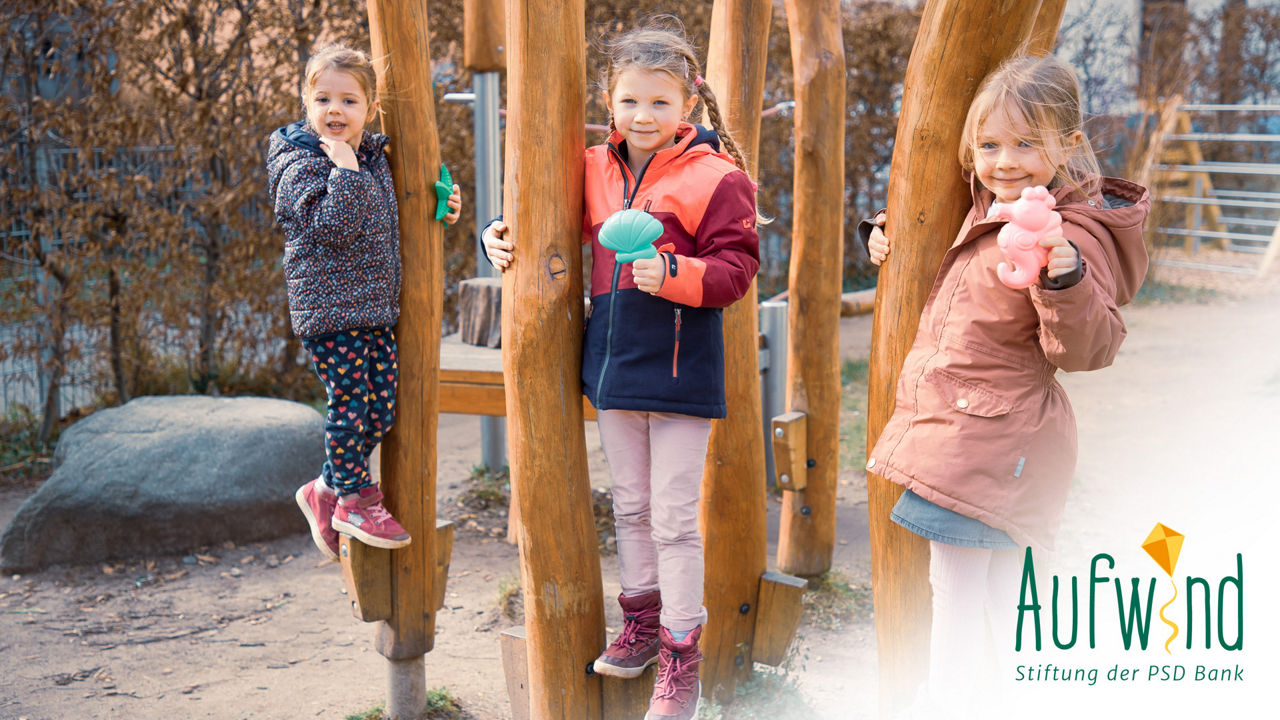 Kinder, die auf einem Spielplatz spielen und in die Kamera schauen.