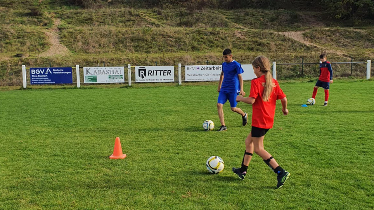 Jugendliche, die auf einem Fußballfeld trainieren.