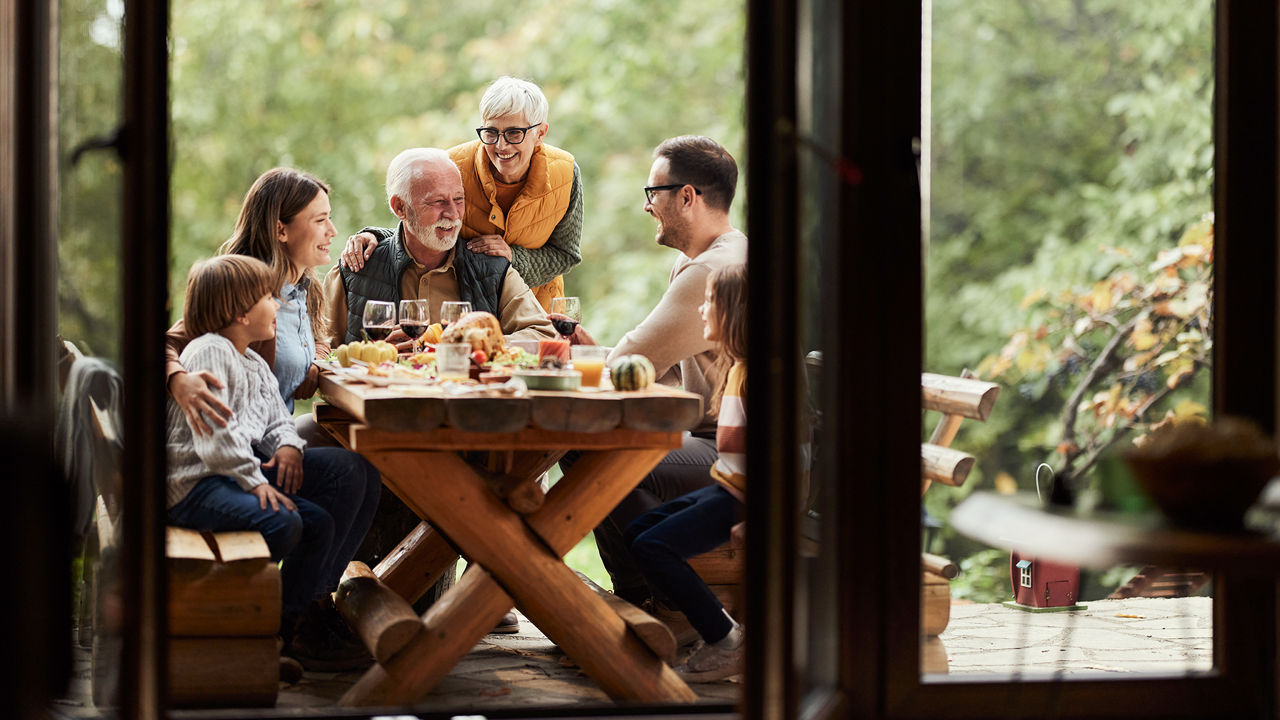 Eine Familie sitzt auf der Terrasse am Tisch.