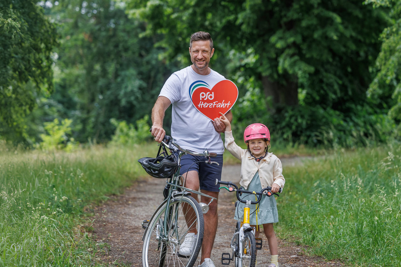 Herzfahrt / Ein Mann mit seiner Tochter mit dem Rad