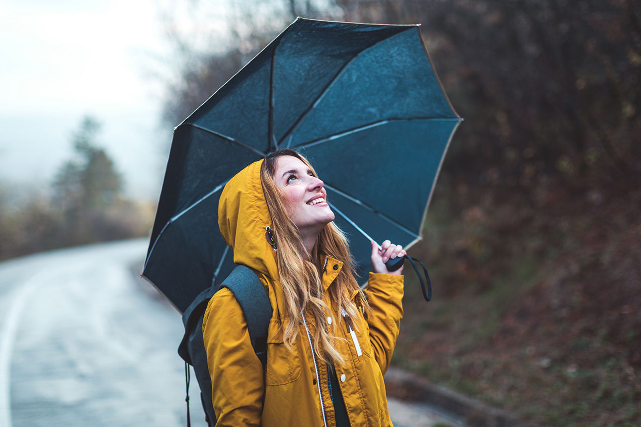 Frau steht unter einem Regenschirm