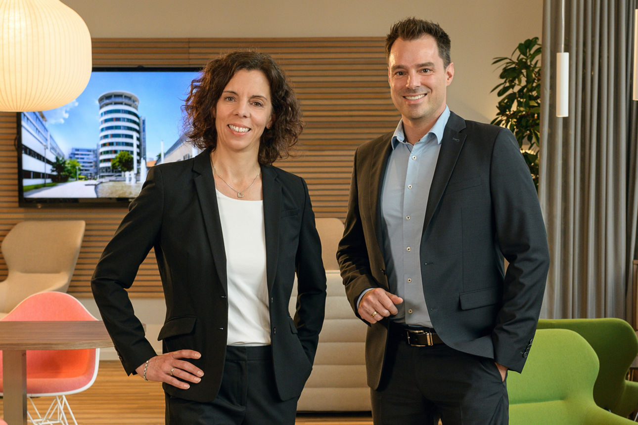 Frau Sonja Kelkel und Herr Christian Berle aus dem Vorstand lächeln in die Kamera. Sie stehen nebeneinander.