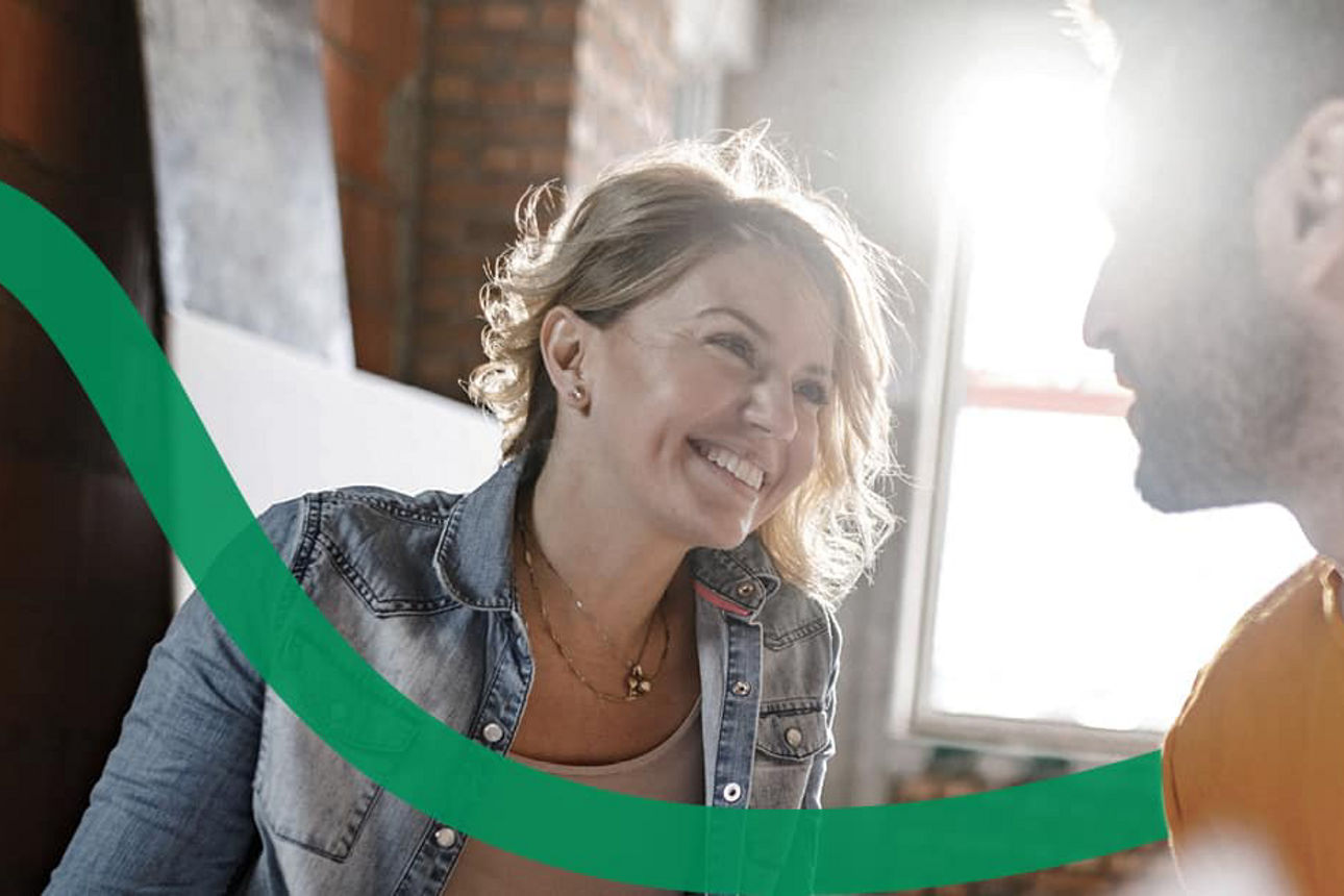 Eine Frau und ein Mann unterhalten sich glücklich auf einer Baustelle