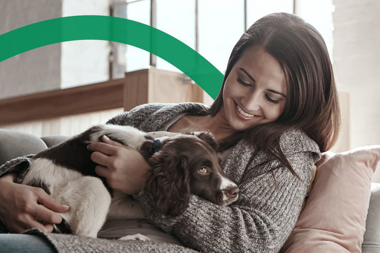 Eine Frau sitzt mit ihrem Hund auf der Couch