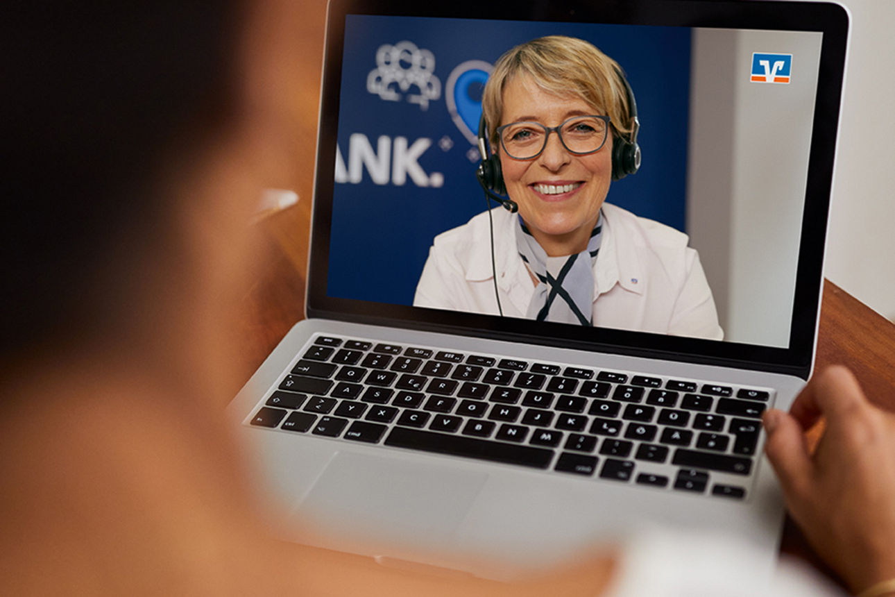Frau hält Laptop in der Hand und nimmt an einer Videoberatung teil