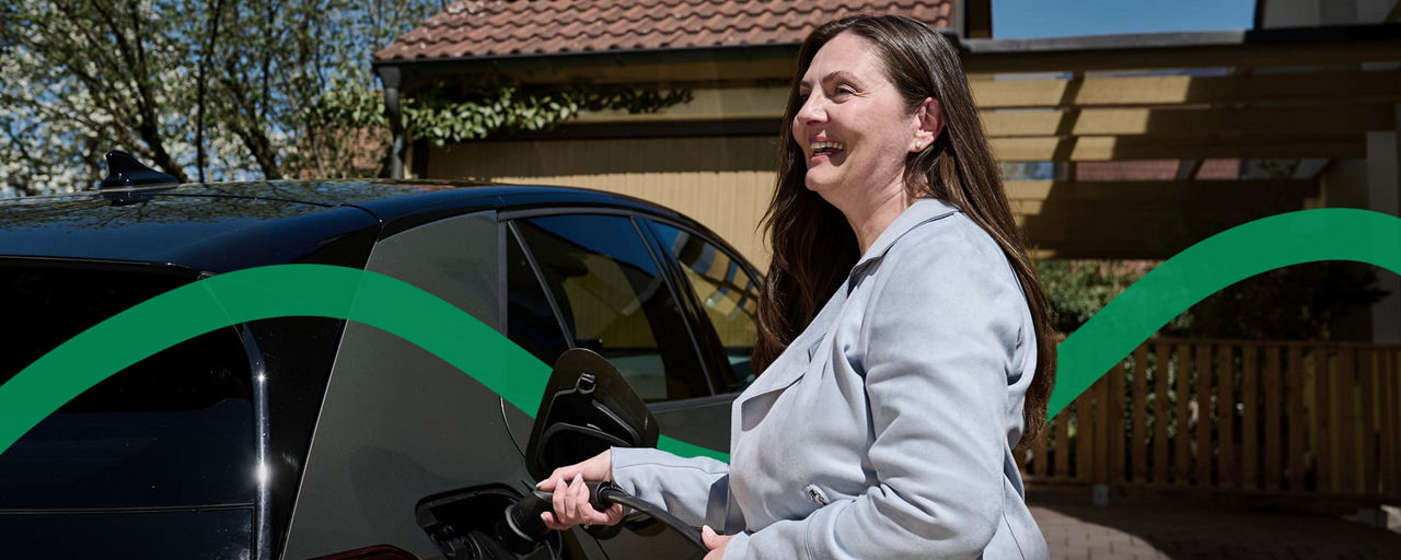 Eine Frau lädt Ihr E-Auto mit dem eigenen Hausstrom auf. 