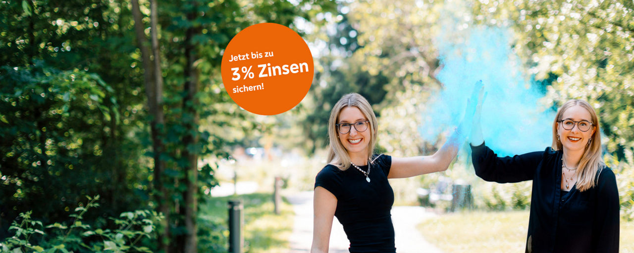 Zwei junge Frauen in schwarz gekleidet, klatschen mit einer Hand ein und blaue Farbe sprüht dabei in die Luft.