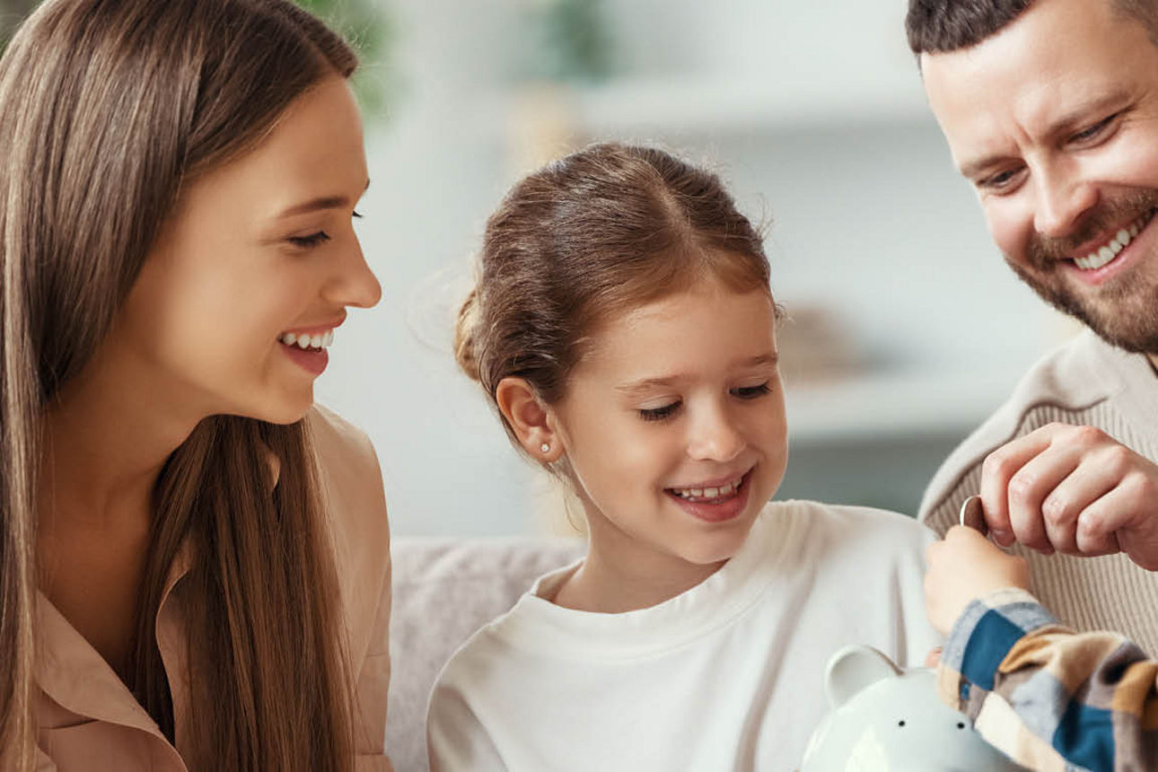 Mutter, Tochter, Vater und Sohn stecken eine Münze in ein Sparschwein